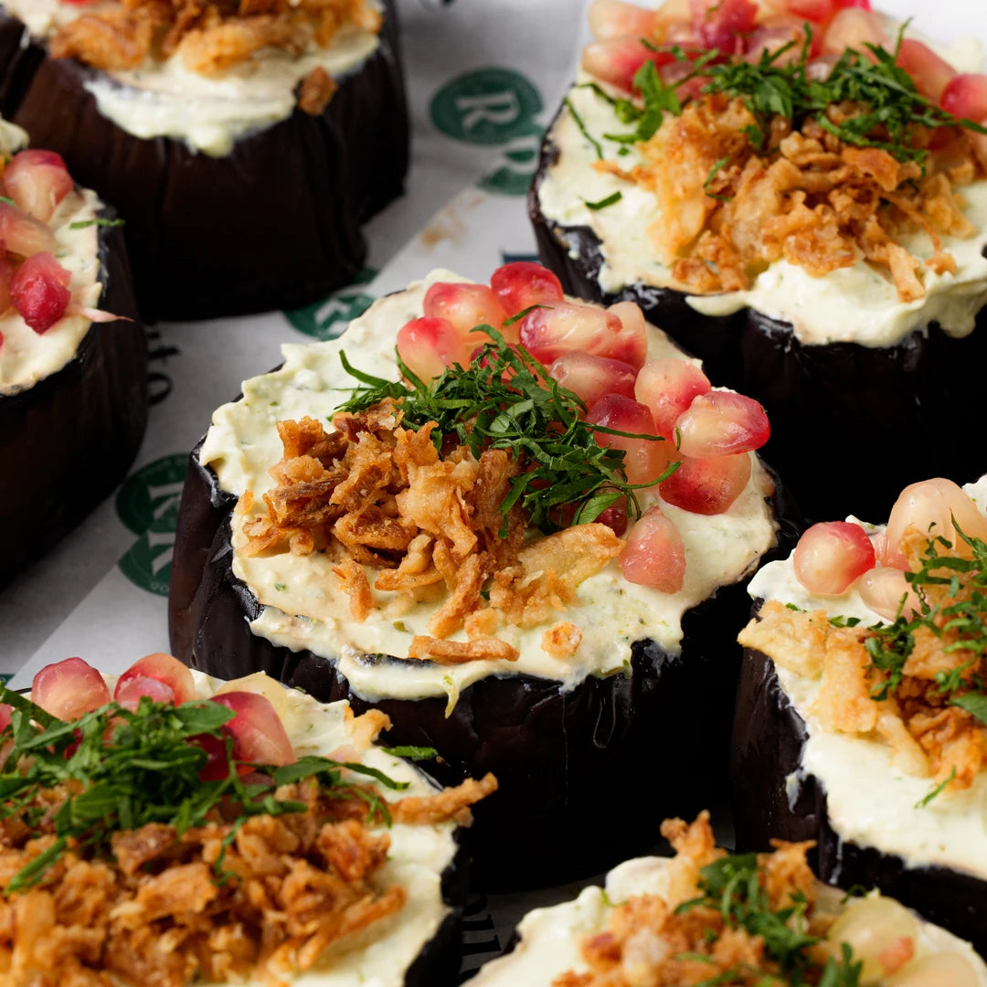 Close up of aubergine discs with feta yogurt and pomegranate, Route Catering London