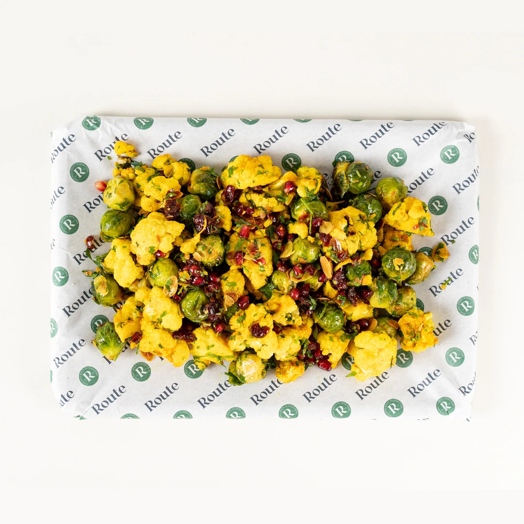 Cauliflower and Brussels Sprouts Salad platter for six from above with turmeric, cranberry and pomegranate on Route Catering paper