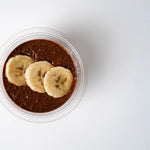 Chocolate chia pot topped with sliced banana, Route Catering London