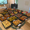 Christmas graze table set up in a London office with platters of festive sandwiches, salads, filo rolls and churros by Route Catering