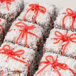 Close-up of Christmas snow square cakes with coconut and red ribbon - Route Catering