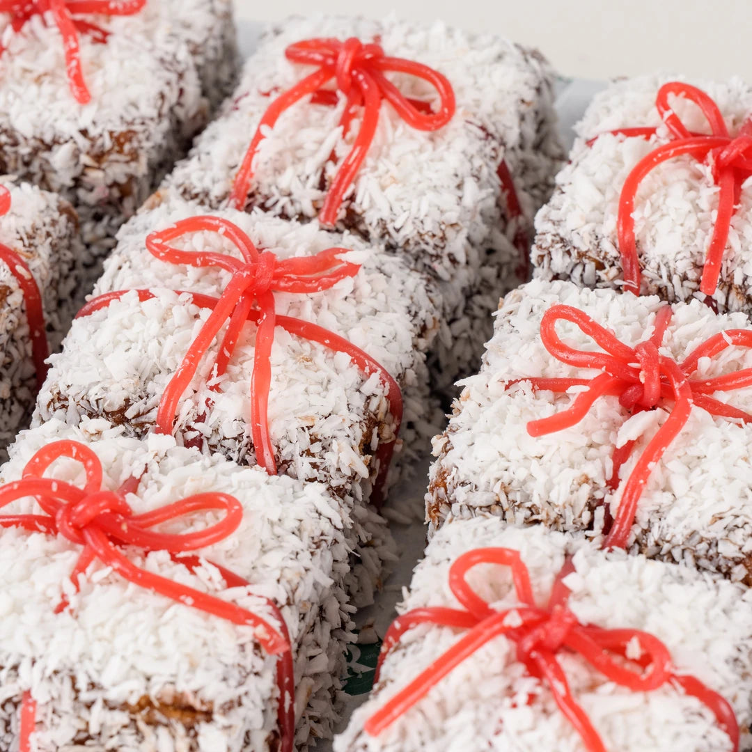 Close-up of Christmas snow square cakes with coconut and red ribbon - Route Catering