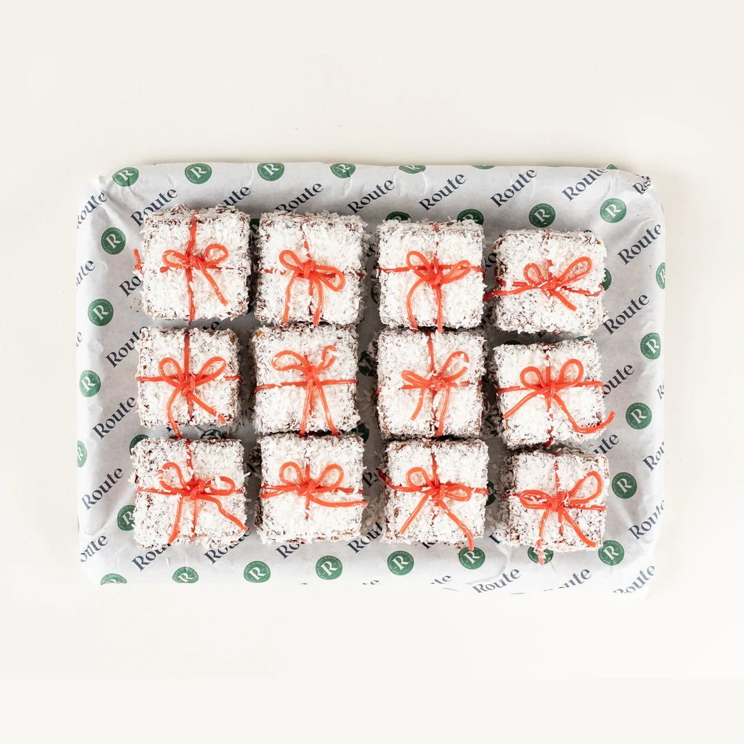 Christmas Snow Square Cakes, 12 coconut-coated squares tied with red ribbon from above - Route Catering