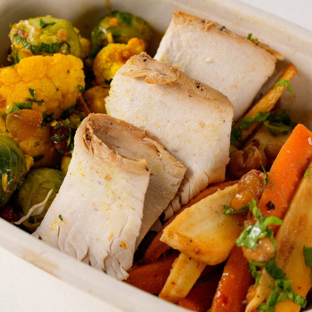 Close-up of sliced roast turkey with roasted carrots and parsnips in the Xmas Turkey Lunchbox - Route Catering
