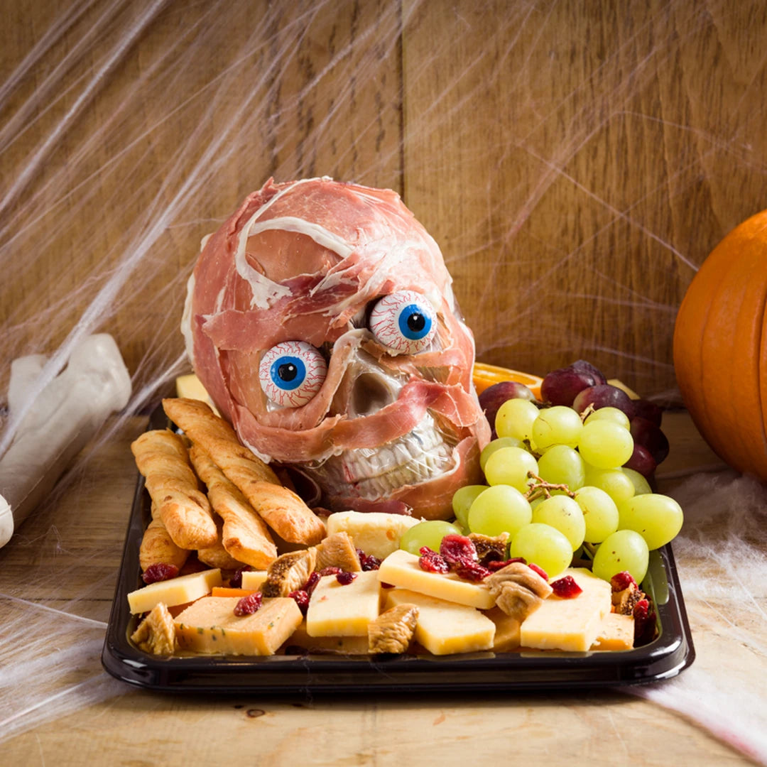 Flesh Board Halloween charcuterie platter with cured meat skull, cheeses, grapes and breadsticks by Route Catering