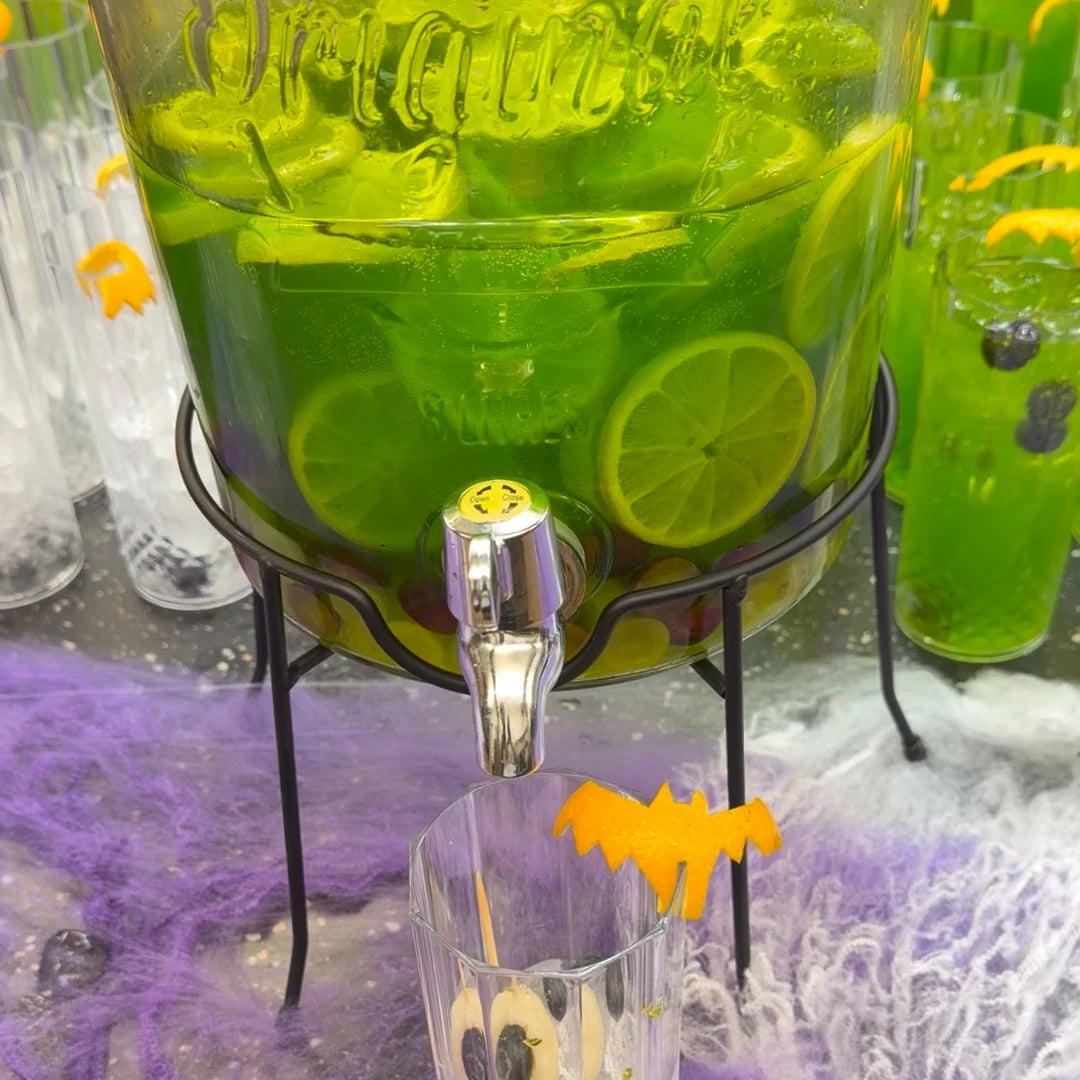 Green Potion Punch drinks dispenser with lime wheels at a Halloween cocktail pop-up