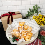 Platter of filo mince pies on Route Catering paper with a wrapped Christmas gift