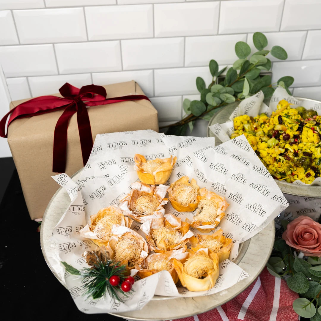 Platter of filo mince pies on Route Catering paper with a wrapped Christmas gift