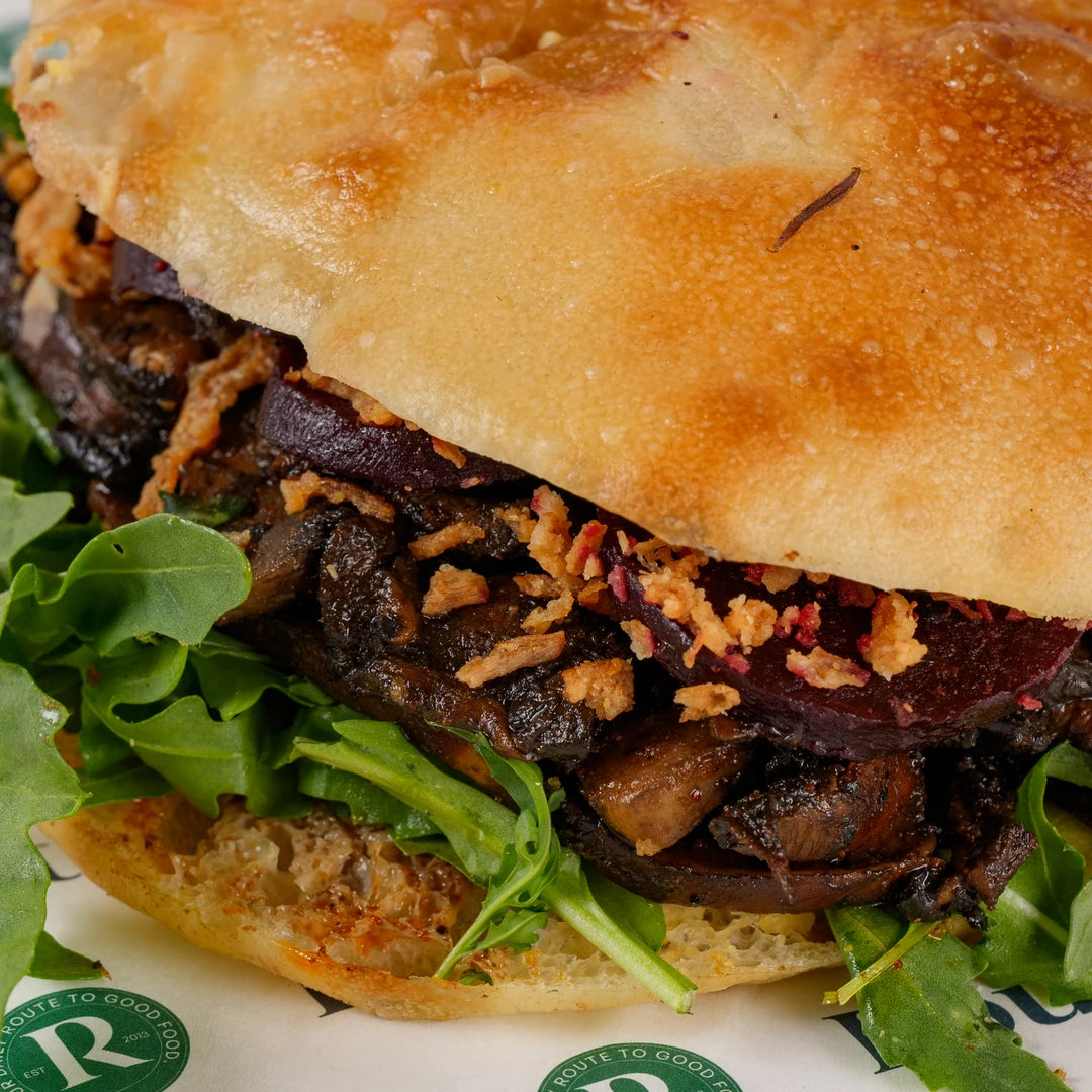 Close-up of the Truffle Mushroom and Maple Beetroot Focaccia filling with crispy onions - Route Catering